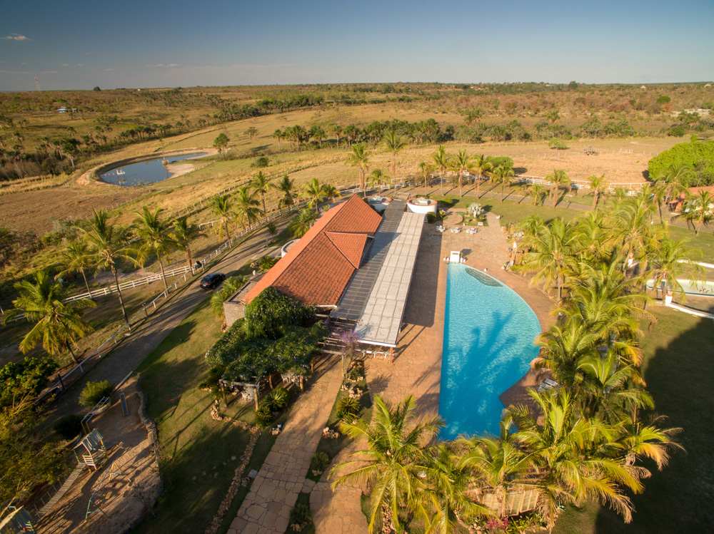 Vista aérea da piscina do Hotel Mar Doce, cercada por palmeiras e pelo restaurante