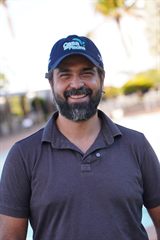 Roberto sorrindo, de boné da Casa da Piscina
